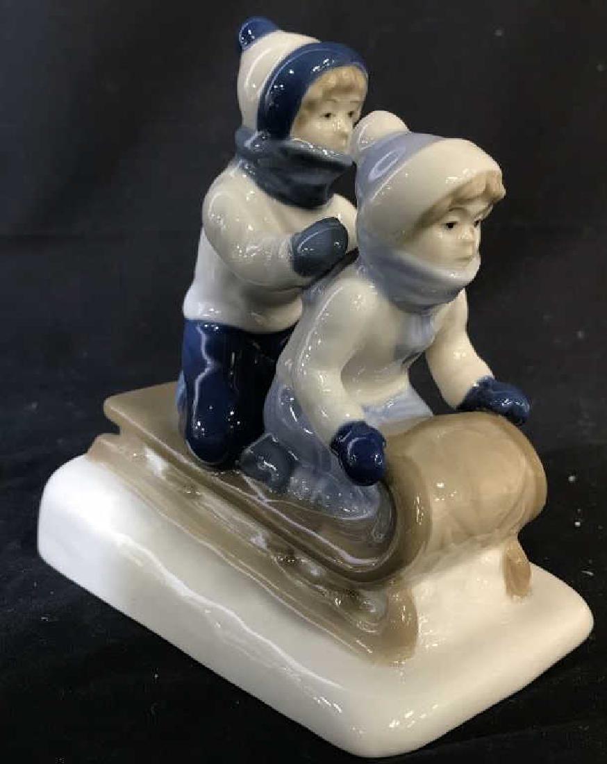 Porcelana De Cuernavaca Porcelain Children Figural: Underside is marked PORCELANA DE CUERNAVACA. Piece is porcelain. Depicts 2 child Figurals sledding. Measures approx 6 inches tall & long 3 inches deep. decorative accessory, home decor, tableware, dec