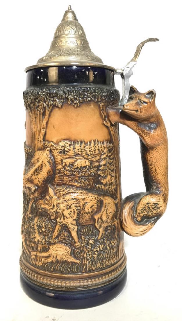 GERZ Ceramic Beer Stein W Pewter Lid: Underside of piece has tag which reads GERZ MADE IN GERMANY. Beer stein has intricate detail with beveled depictions of various animals including deer, hogs, and foxes. Contains fox shaped handle. Lid