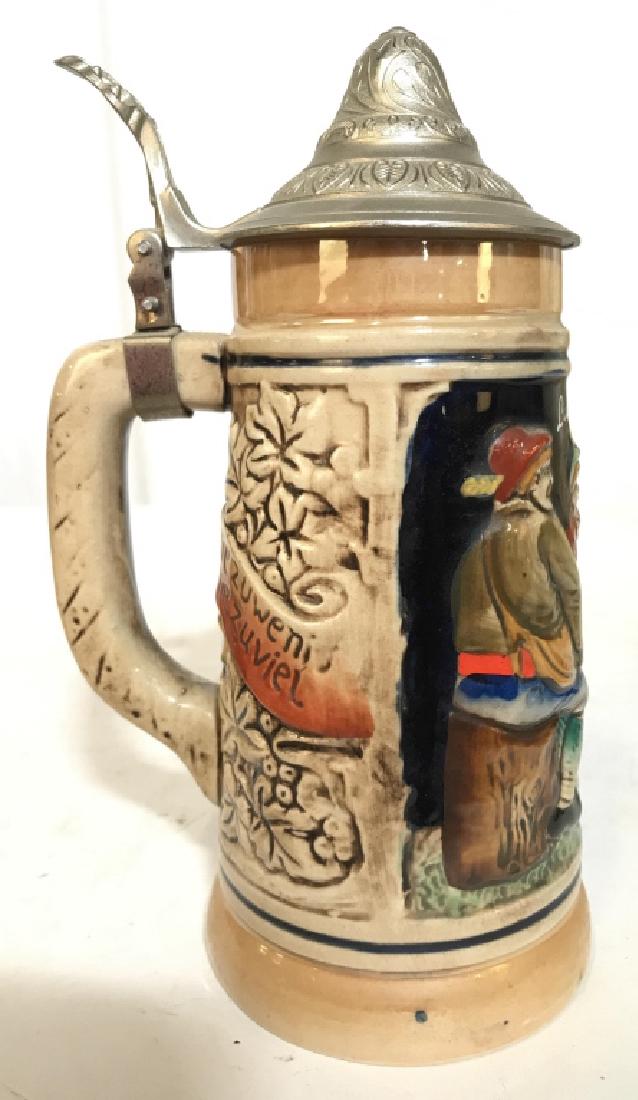 Ceramic German Beer Stein W Pewter Lid: Beer Stein is ceramic. Contains beveled painted depiction of 3 figures. Piece appears to possibly be hand painted. Lid is silver toned and Pewter. handle. drinking vessel, barware, decorative accessor