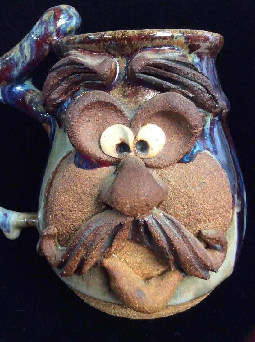 Signed Ceramic Pottery Face mug: Signed illegibly on underside, sculpted face design, whimsical character mug, blue and earth toned glaze. Earthenware, Stoneware, mug, coffee tea mug, tableware. Measures approx 6 in by 6 in by 4 in. 