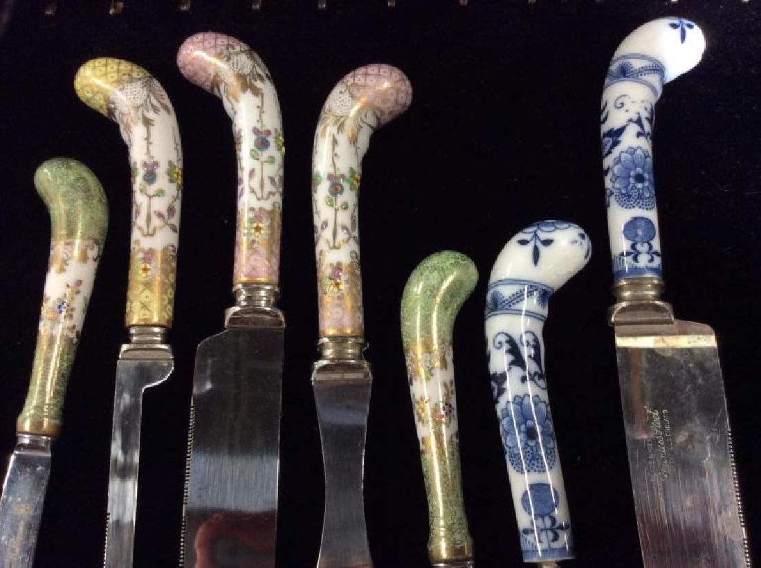 A E LEWIS & CO Porcelain Handled Serving Utensils: Set 7 A E LEWIS & CO Porcelain Handled Serving Utensils, pieces marked A E LEWIS & CO Sheffield England, rainless Steel. Porcelain handles with gold toned details and floral design, some surface wear.