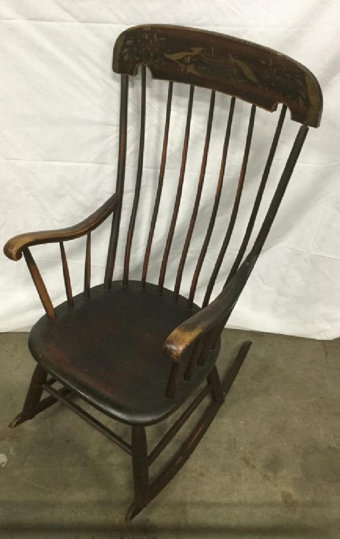 Vintage Wooden Rocking Chair: Chair had gold tone pattern detailing. Some fading of color on wood surface. Measures approx 43 inches in height by 23.25 inches in width by 18.5 inches in depth. Vintage rocking chair, rocker, interi