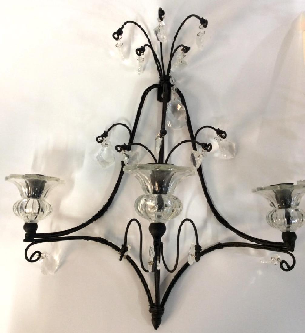 Black Toned metal Wall Sconces: POSs Cast Iron, with hanging glass prisms and catch dishes. Once sconce has three candle style electric inserts, not tested, measures app 17 in by 16 in by 7 in. Wall sconces candelabras, candleholder