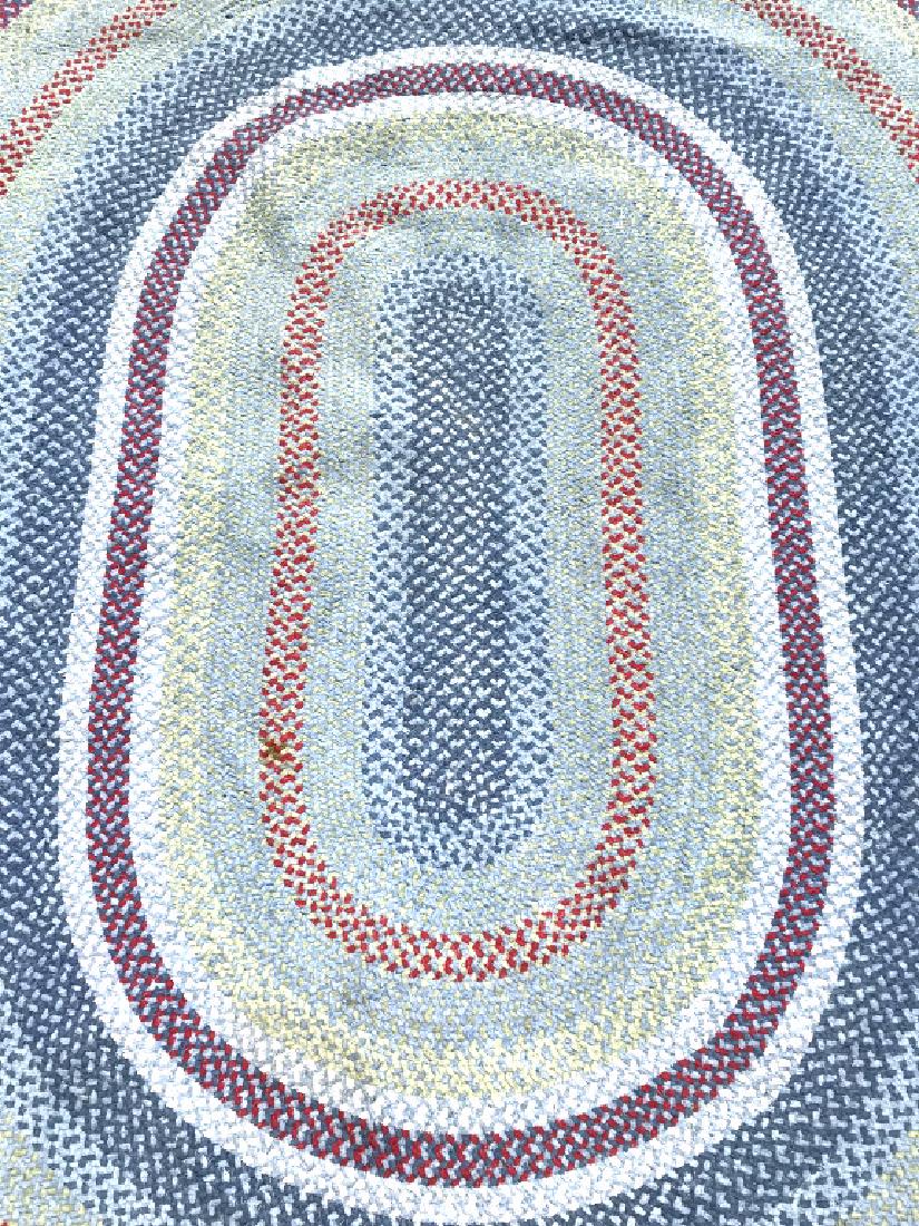 Multi Toned Braided Oval Wool Rug: Rug is braided & oval shaped possibly handmade. Contains tones of red, blue, green & sky blue. Measures approx 110 inches long 85 inches wide. Contains some small holes. Need cleaning. rug carpet, hom