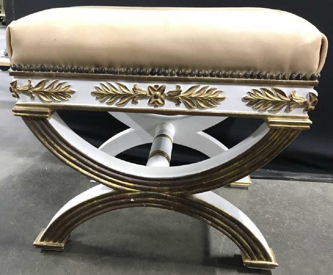 Regency Style Leather Top Wooden Bench: Bench has regency style. Bench is wooden with ornately carved wooden detail. Piece is whir and gold toned with tan toned leather cushion. Measures approx 19 inches tall & long, 14 inches deep. X bench