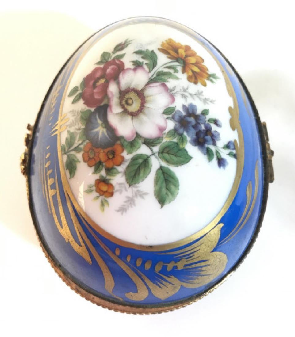 LIMOGES FRANCE Egg Shaped Porcelain Trinket Box: Underside of piece is marked LIMOGES FRANCE. Piece has blue tone with gold toned painted detail and multi toned floral detail on top. Measures approx 4 inches long 2.5 inches tall & deep. decorative a