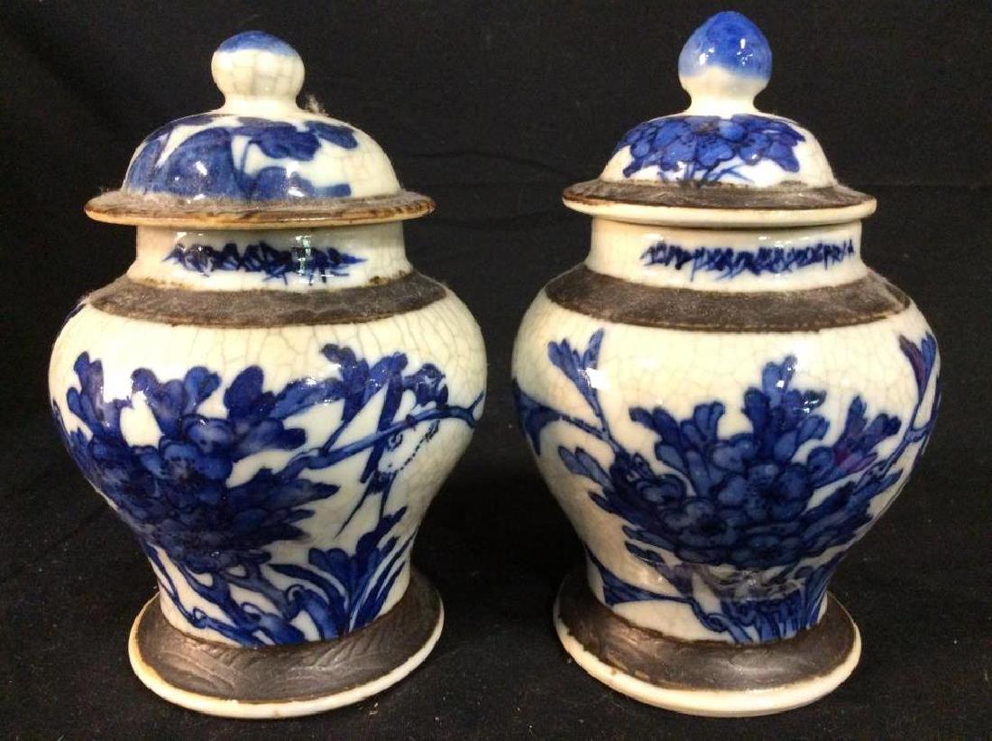 Pair Vintage Ceramic Ginger Jars: Ginger jars are vintage possibly antique. Ginger jars are ceramic. Pieces are grey toned with blue toned floral & leaf detail. Both include lid. Measures approx 6.5 inches tall 4 inches wide. Contain 