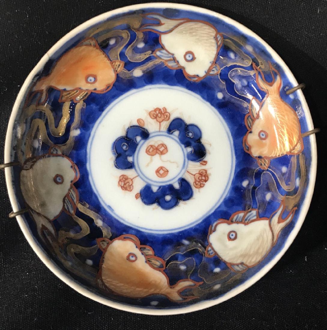 Lot 4 Antique Japanese Imari Porcelain Saucers: Antique Japanese Imari porcelain saucer plates with fish pattern . Saucers measure approx 4.25 inches in diameter. Plates have display wires. Some minor fading of gold tone trims. Antique Japanese por