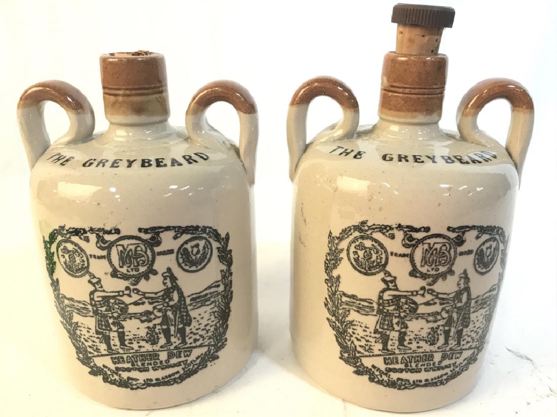 Lot 2 Vintage Dual Handled Ceramic Jug: Lot includes 2 ceramic jugs each with 2 handles. Pieces are grey and light brown toned. Each have cork cap. 1 cork cap is broken. Front of pieces read THE GREYBEARD undersides reads MADE IN SCOTLAND.
