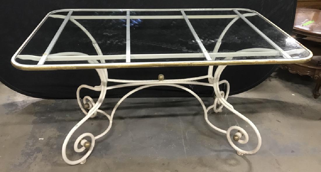 Forged Metal And Glass Topped Table: Forged Scroll Design Metal Base Table In white toned painted finish and brass toned highlights, with glass top, measures approx 55 inches long x 33 inches deep x 29 inches tall, needs cleaning, chips