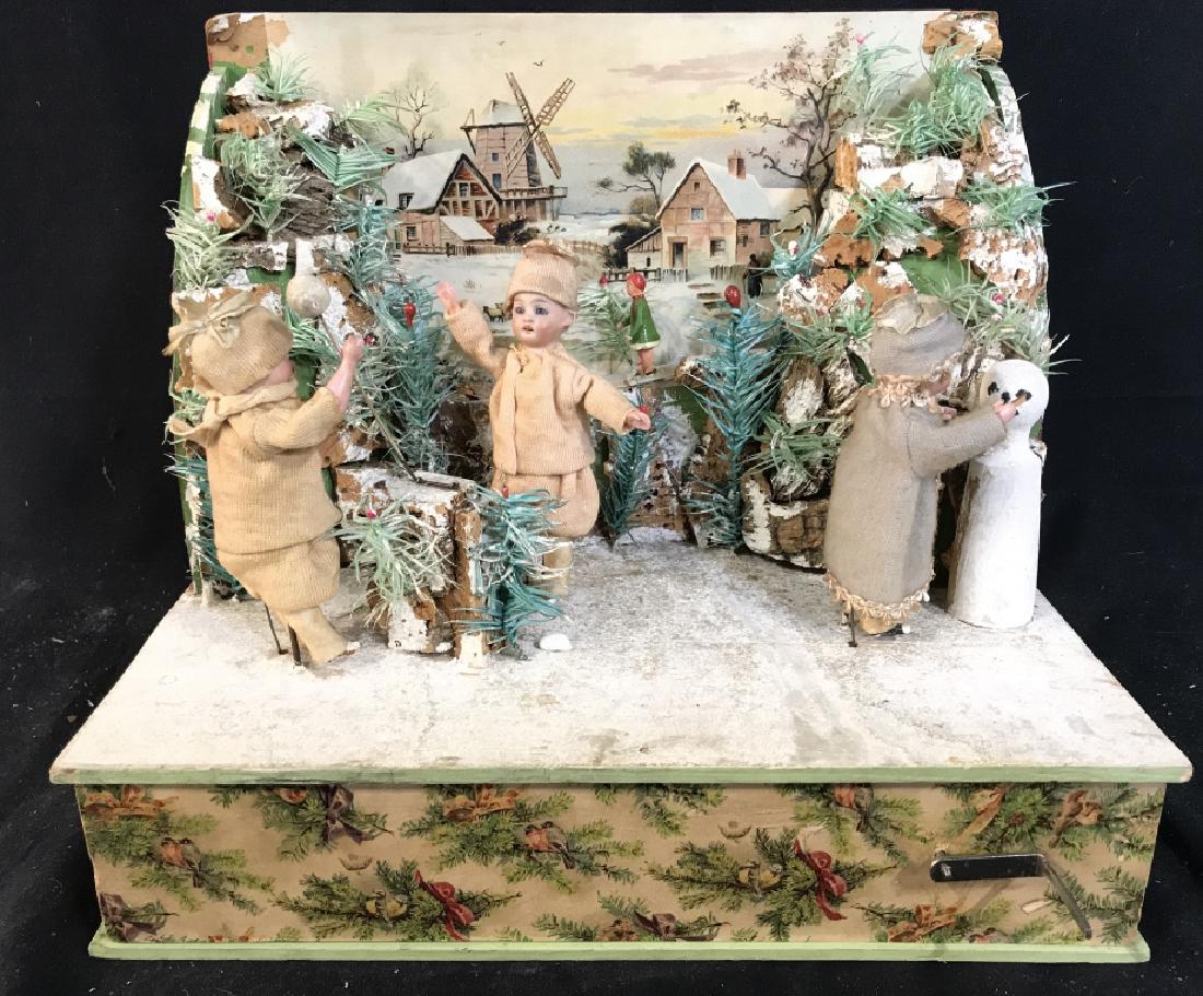 Antique Christmas Music Box: Music Box has silver toned metal crank on front. Depicts 2 child figures throwing a ball, and one building snowman. Music box has moving pieces. Measures approx 12 inches long 10 inches tall, 8 inches