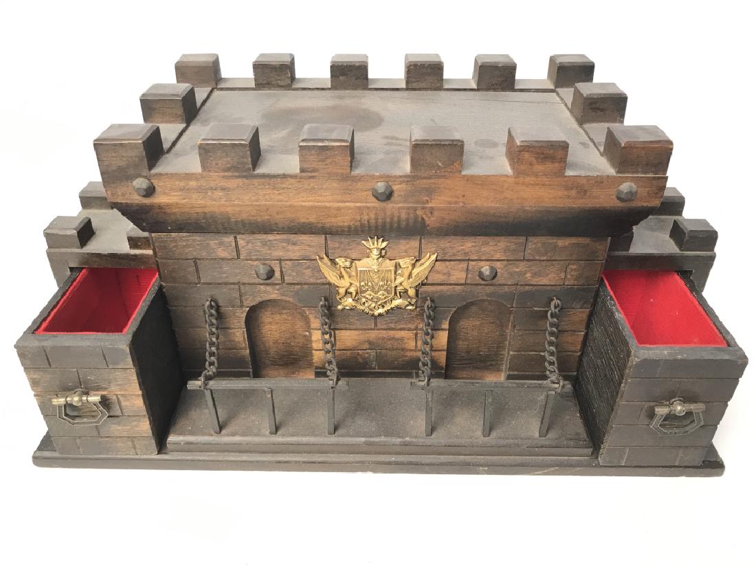 Carved Wooden Castle Shaped Jewelry Box: Jewelry box is brown toned with gold toned emblem on front. Contains lid on top. And 2 slide out compartments on side. Measures approx 13.5 inches long 6.5 inches tall and deep. Jewelry, keepsake box,