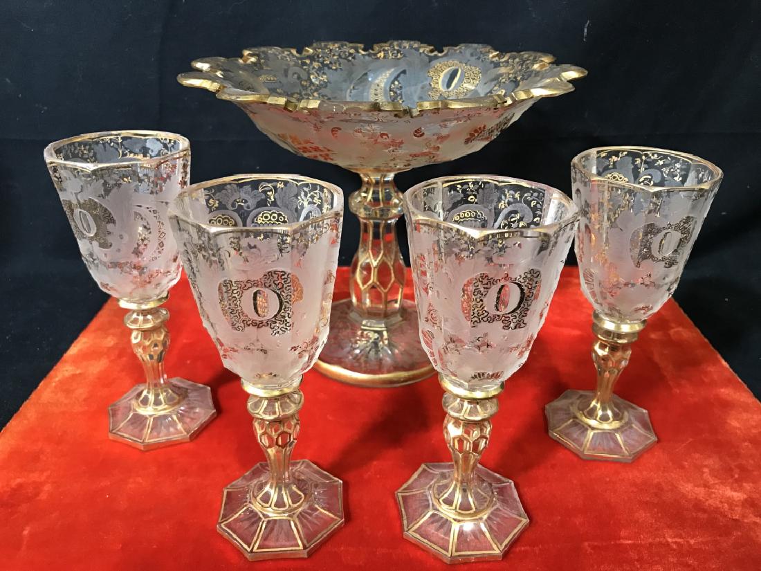 Lot 5 Compote & Wine Glasses W 22kt Gold Details: Lot includes 1 compote dish and 4 wine cordial aperitif glasses. Possibly antique. Etched glass, possibly crystal, with 22 karat gold swag details and trims. Each dish is marked with letter ‘O’ in