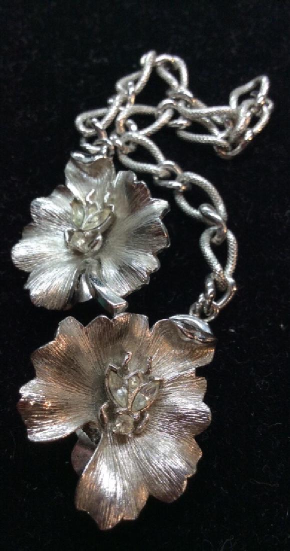 TRIFARI Convertibles Ear Clips / tie Clip: Description Trifari Ear clips with small chain to be worn as Tie clip. Silver toned metal with floral design, with rhinestone accents, some discoloring to metal. Measures approx 9 in long. Women’s v