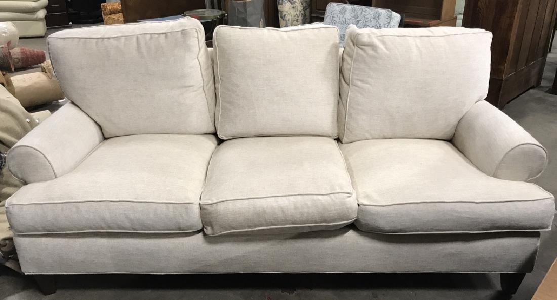 Tan Toned Loose Cushion Sofa: Sofa is tan toned. Contains 3 seat cushions. Measures 83 inches long 38 inches tall, 39 inches deep. Property of Country Willow Furniture Bedford Hills New York. Contains brown toned wooden feet. Cont