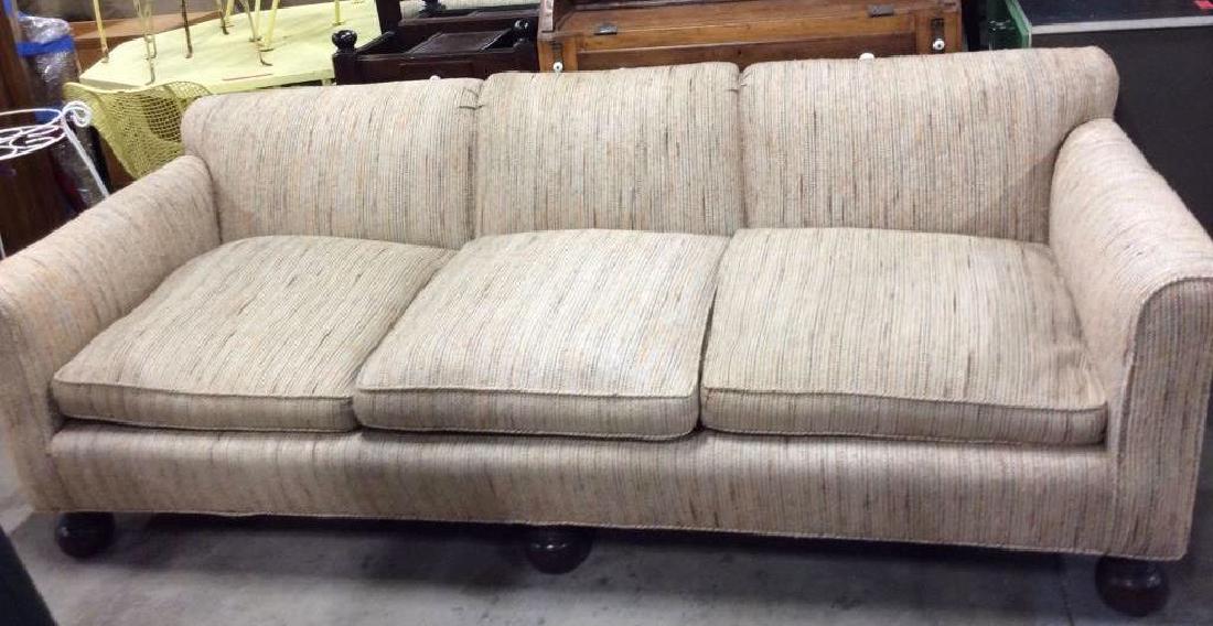 Woven Fabric Upholstered Sofa: Beige, blue orange and green toned woven fabric couch with dark toned wood ball feet. Some wear to fabric and pulling to weaves but free of stains or tears Measures approx 28 8n tall, 86 in long by 36