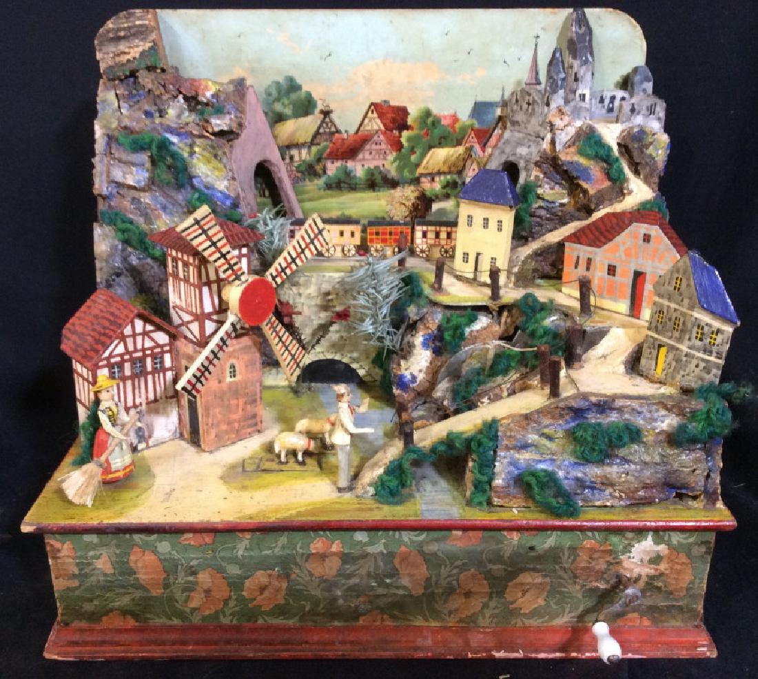 Antique Wooden Music Box: Music box is antique & wooden. Music box depicts us village scene with multiple houses, a windmill, multiple figures, & a train. Front of piece has crank. Measures approx 10.5 inches tall 12 inches wi