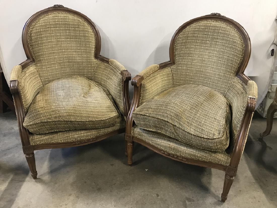 Pair Bergere Style Curved Back Arm Chairs: Pair Bergere Style arm chairs. Wood frame with carved floral details, tapered feet. Each measures approx 38 inches in height by 27 inches in width by 20 inches in depth. Removable cushions will need r