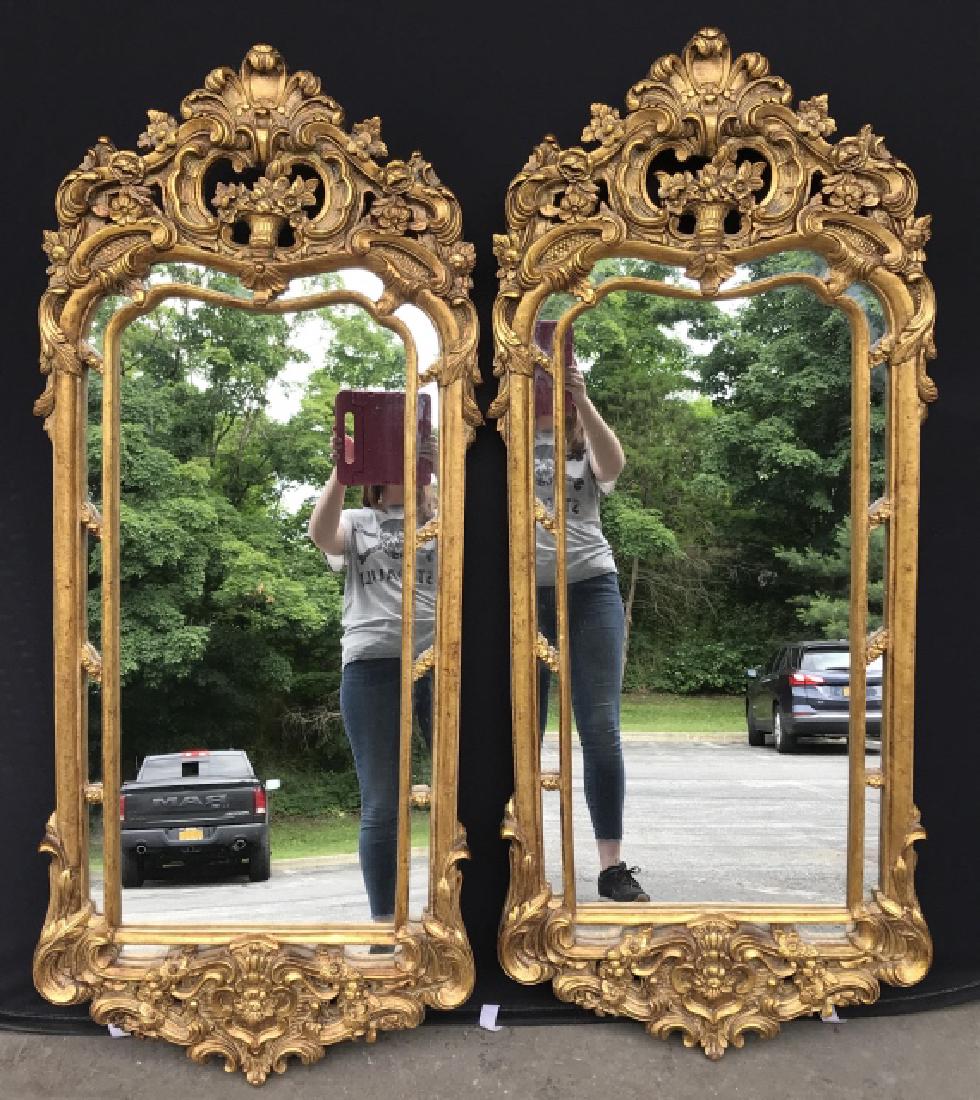Pair Pier Mirrors W Ornate Floral Basket Pediments: Pair of pier mirrors in ornate gold tone carved and pierced gesso over wood frames, frames have floral and flower basket style pediments. Each measures approx 58 inches in height by 23.5 inches in wid