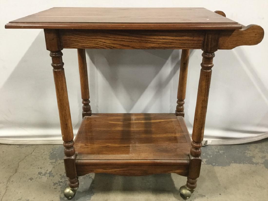 Vintage Carved Wooden Beverage Cart: Bar cart is wooden, contains carved wooden handle. Contains 4 gold toned wheels. Measures approx 31 inches long, 30 inches tall, 19 inches deep. Tea cart, bar cart, beverage cart. 6