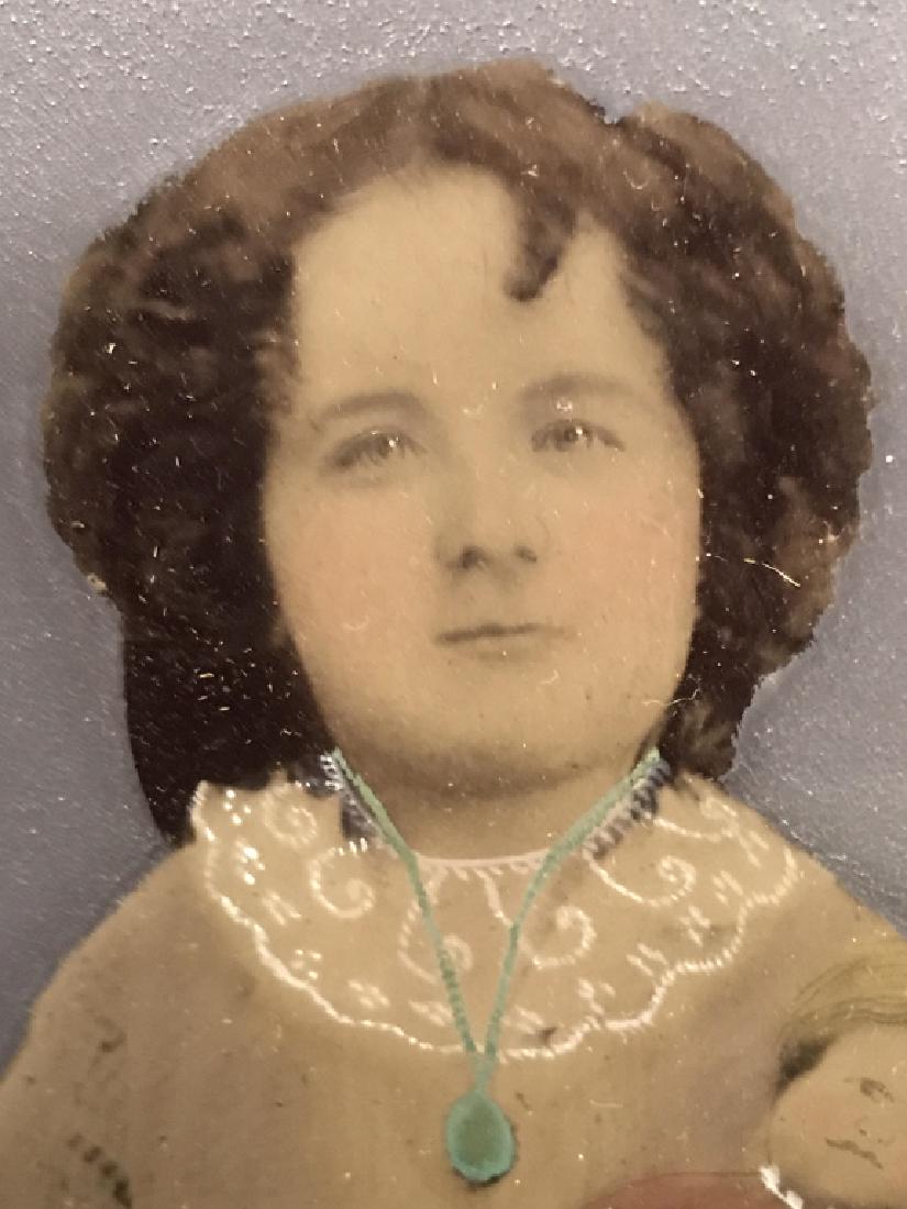 19th Century Ambrotype Painted Photo, Girl W Doll: Ambrotype, painted photograph, depicting girl with doll, Circa early 19th Century. Verso has original photographer’s label, although illegible due to fading and wear. Ambrotype is matted and set in 