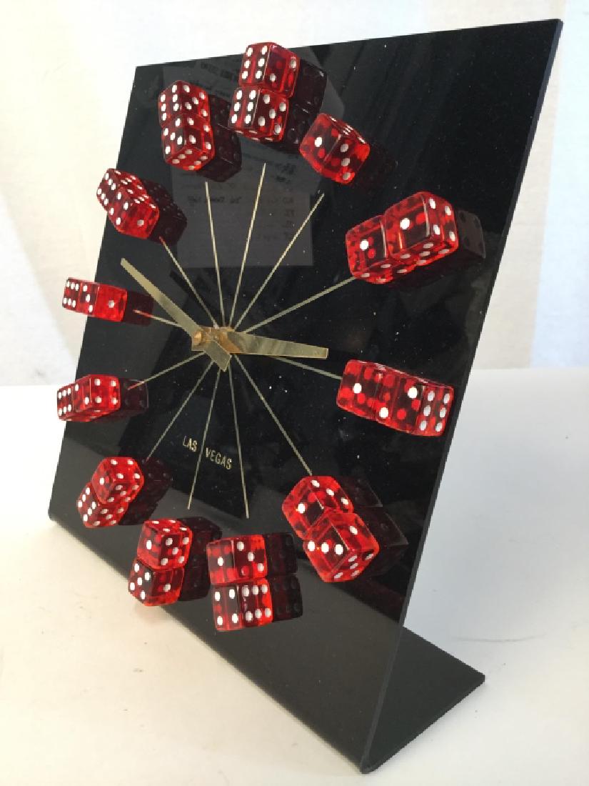 LAS VEGAS Dice Desk Clock: Piece is marked LAS VEGAS. Piece has red & white toned dice as the clock numeral. Piece is black and gold toned. Measures approx 9 inches tall and wide, 3 inches deep. collectible, home accent, mantle