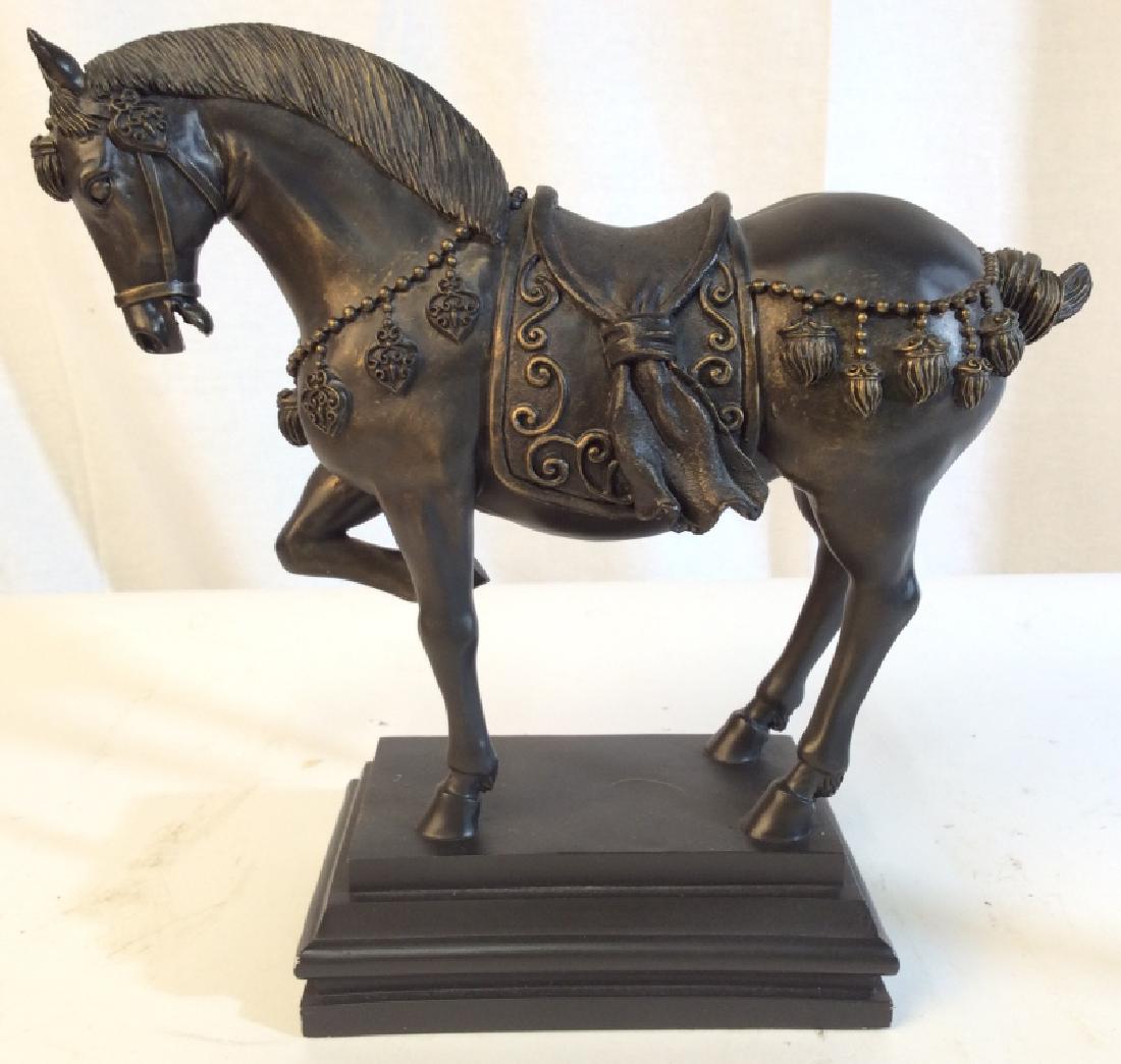 Black Toned Composite Horse Figural: Horse Figural is black toned. Piece depicts a horse with one raised hoof wearing a saddle and various ornaments. Measures approx 10.5 inches long 10 inches tall, 4 inches deep. Mantle piece decor, ani