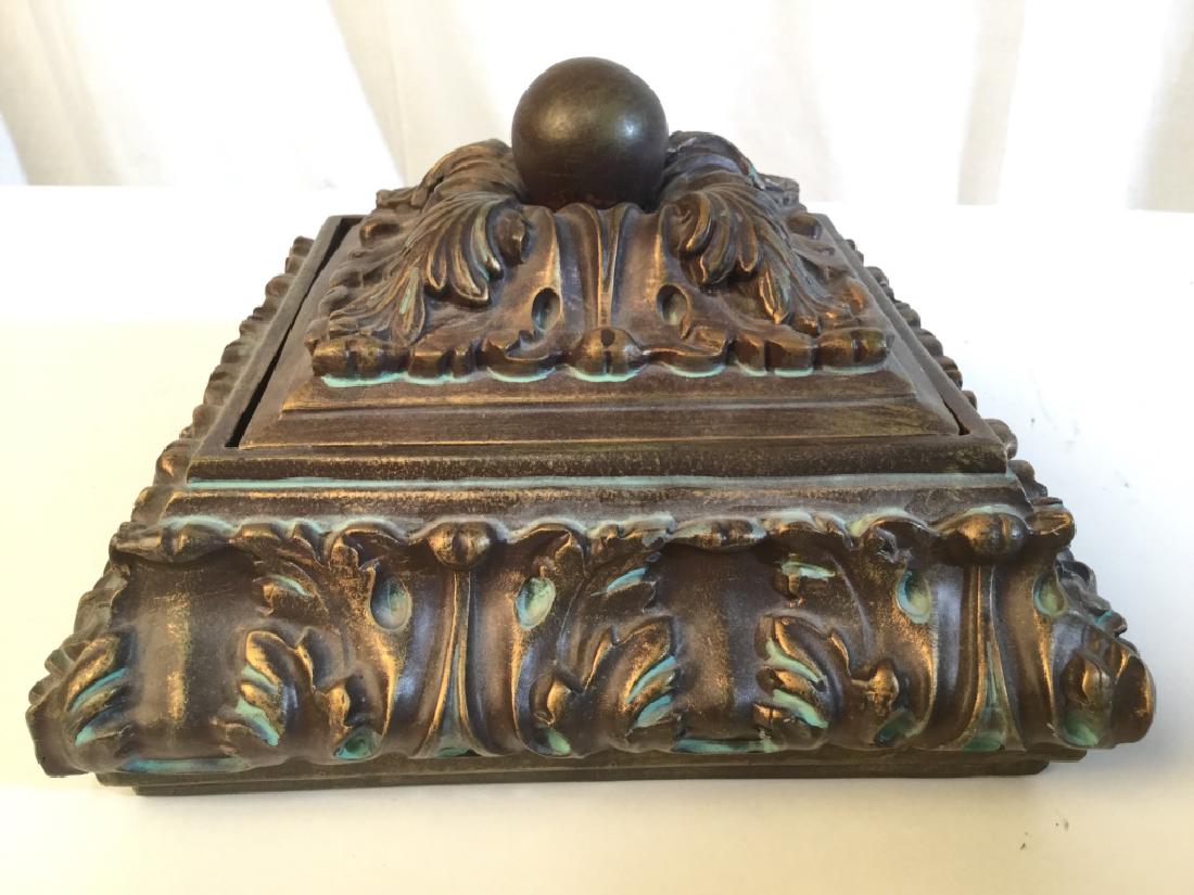 Intricately Carved Keepsake Box: Box appears to be wooden, possibly composite. Keepsakes Box, Jewelry box, trinket box. Piece includes lid. Piece has piece has a dark gold tone and intricately carved detail. Measures approx 10 inches