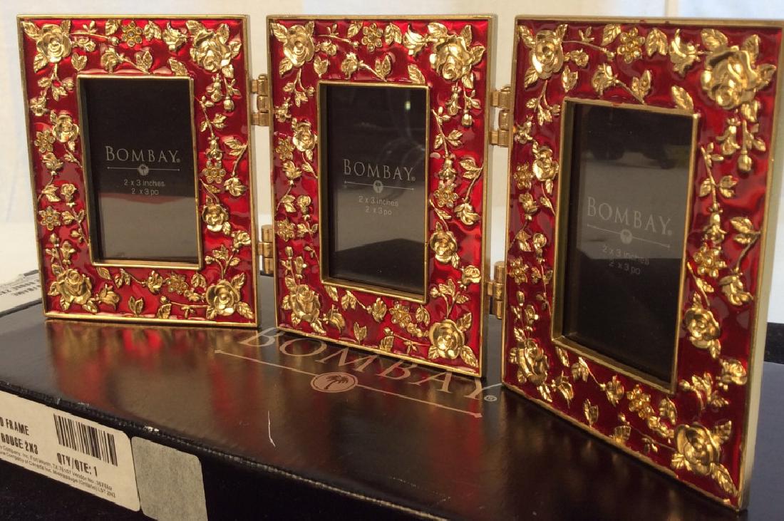 Bombay & Co. 3 Pc Red & Gold Enameled Frame Set: New in Box. Gold Enamel Roses On Cherry Red. Frames are Linked Together, measuring 9.5 x 4 as a whole. Individual frames are 3 x 4 and photo size is 2 x 3. Bombay & Co. Frame, Enameled Mini Frame Set,