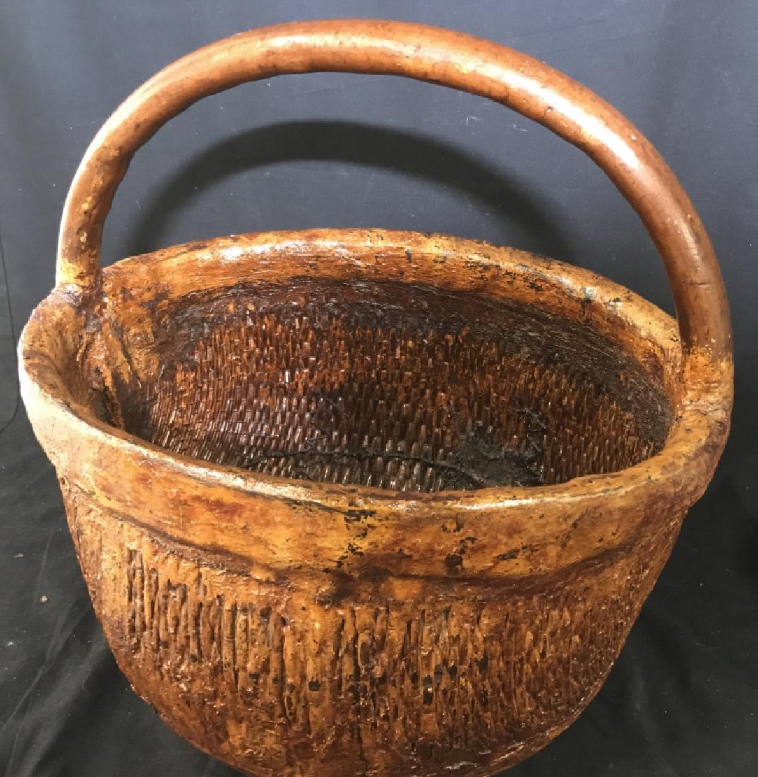 Vintage Handcrafted Oval Shape Floor Basket: Wood Handle. Base of Basket possibly composite material over woven grass. Detail of of woven material shows on both interior and exterior, giving it a unique characteristic. Some surface cracks, other