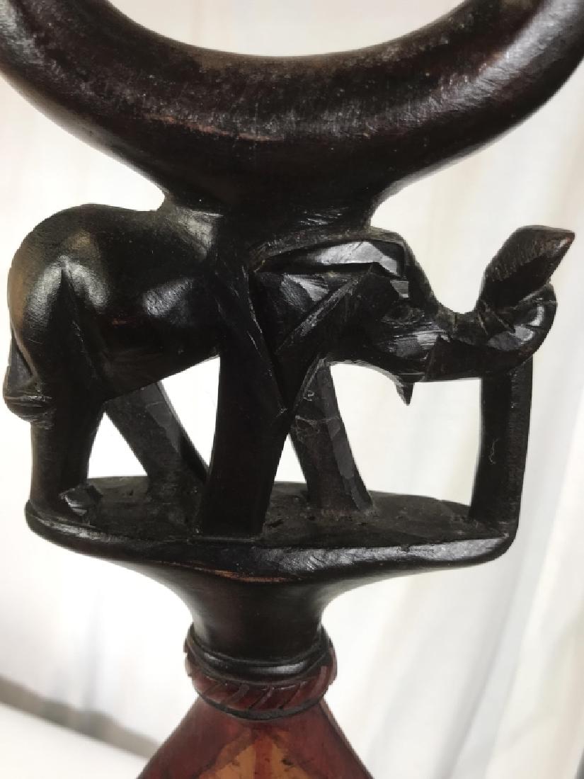 Vintage Hand Crafted African Walking Stick: Main Attraction is the enchanting Elephant, whose trunk is in an upright position. Handle is a circle Design. Rope Carved From Bottom into a diamond shape separates the main carving of the elephant. S