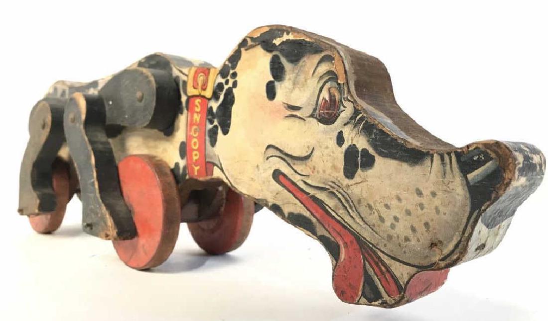 Vintage Carved Wooden Dog Pull Toy C 1970’s: Pull Toy is vintage. Piece depicts a Dalmatian dog on wheels. Measures approx 16 inches long 5 inches tall. Piece reads “SNOOPY” ON collar. Fisher Price Toys Some evident and significant loss of p