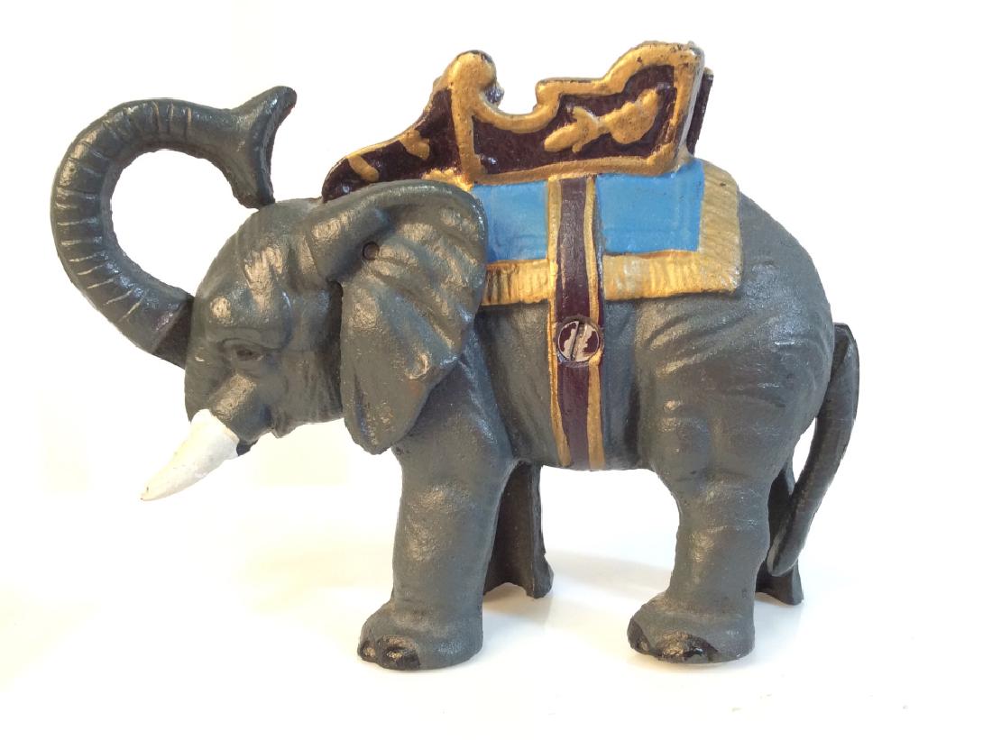 Cast Iron Elephant Bank: Coin rests in trunk and tail moves move trunk, tosses coin. W moveable trunk and tail, elephant Figural statue bank, painted cast iron metal some loss of paint. 5 in by 7 in by 2 in, bank, Coin bank,