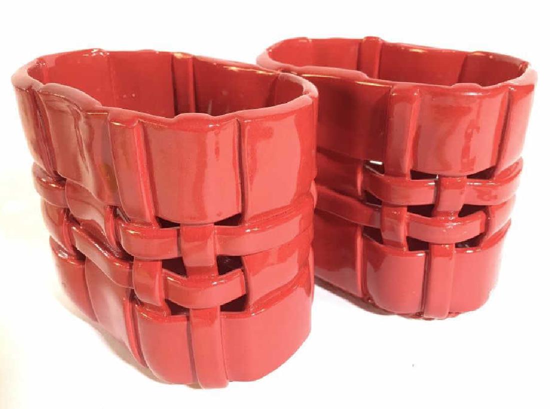 Pair PRIMOGI Italian Porcelain Baskets: Underside of pieces PRIMOGI HANDMADE IN ITALY. Pieces are red toned. Both have a woven basket appearance. Contains minor imperfections. Each measures approx 5.5 inches tall 6 inches wide, 4 inches dee