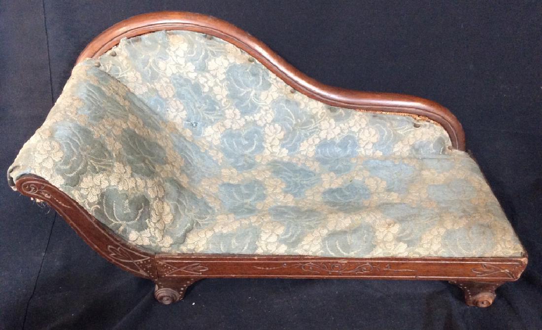 Antique Doll House Fainting Couch: Carved wood miniature fainting couch with blue toned fabric upholstery with floral design, doll house furniture, collectible, doll bed. Evident wear to upholstery, some surface wear to wood, measures 