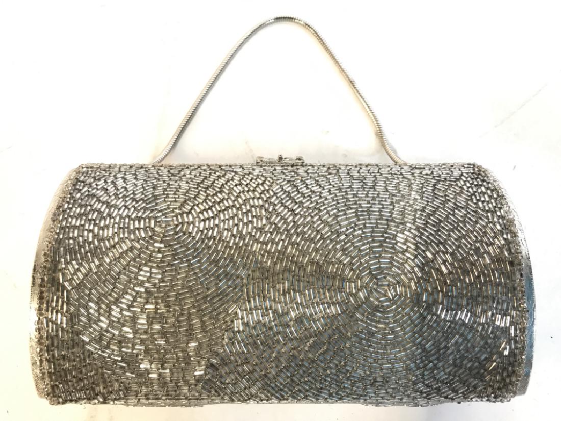 Silver Toned Beaded Clutch & Coin Purse: Clutch is silver toned. Contains intricate beaded detail. Lot also includes vintage coin purse. Piece measures approx 8 inches tall when hanging, 6 inches long, 2.5 inches deep. Contains some wear som