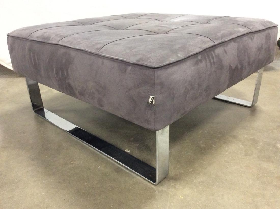 Bo Concept Grey Toned Ottoman W Chrome Base: Tag reads BO CONCEPT. Ottoman has a dark slate toned. Piece has chrome base. Measures approx 36 inches square 17 inches tall. Has stains. Home furnishings, home accessory living room furniture, lounge