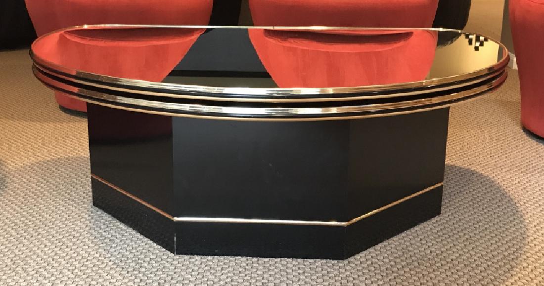 Unique Coffee Table W Swivel Mirror Top: Coffee table has mirrored surface top in semi-circle shape, which revolves in two positions to form a full circle, oval with the underlying table base. Brass banding details. Coated wood composite bas