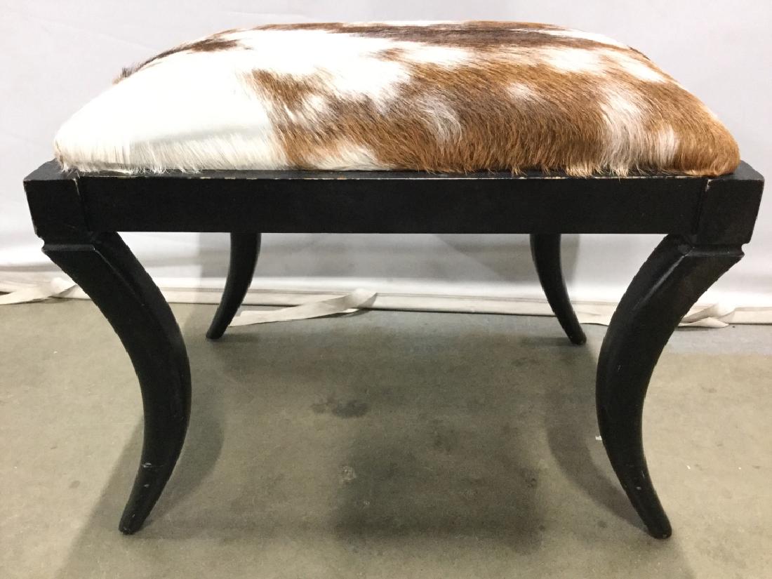 Cow Hide Seat Wooden Bench: Seat of bench appears to be cowhide. Bench frame is black toned and wooden. Measures approx 23 inches long 17 inches deep, 19 inches tall. Bench, ottoman, foot rest stool, home accent home furnishings