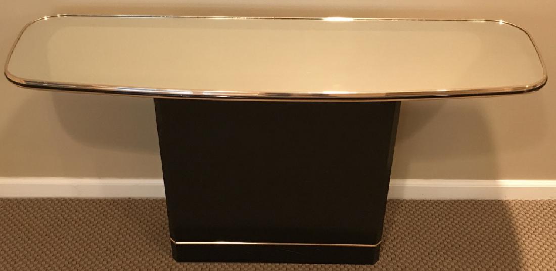 Contemporary Mirror Top Side Table: Brass banding details. Coated wood composite base. Measures approx 27 inches in height by 51.5 inches in width by 15.5 inches in depth. Mirror top might need cleaning/restoring, has light scratches. I