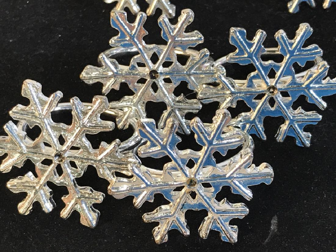Set 11 Snowflake Napkin Rings: Silver Toned And Shiny. Snowflake Design Measures 1 1/5 all around. Napkin ring dia. measures 1 1/4. 4 are missing rhinestones in center. Holiday Napkin Rings, Dinner Napkin Rings, Seasonal Napkin Rin