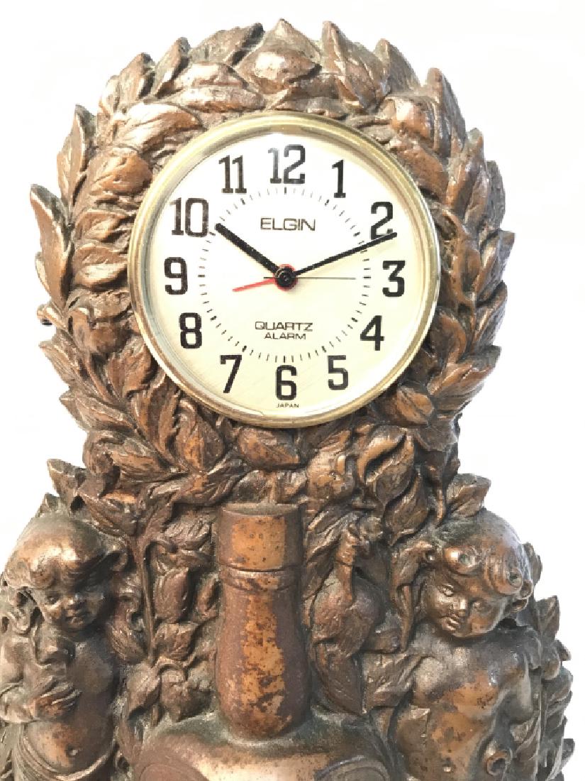 Cherub Flanked Metal Clock: Repossessed heavy metal possibly Iron, copper toned, clock face reads Elgin, Quartz Alarm, base has center bottle that reads Try OLYMP Root Compound, base reads OLYMP Root compound Co, Louisville Kent