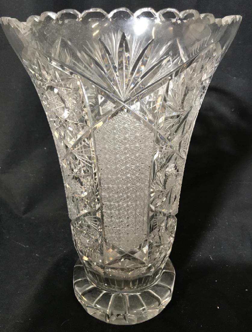 Footed Toothed Cut Crystal Vase: Vase is cut crystal. Piece is footed. Rim of vase is toothed. Measures approx 14 inches tall 9 inches wide. Contains some minor nicks. Tableware, decorative arts and accessories, accent piece, mantle 
