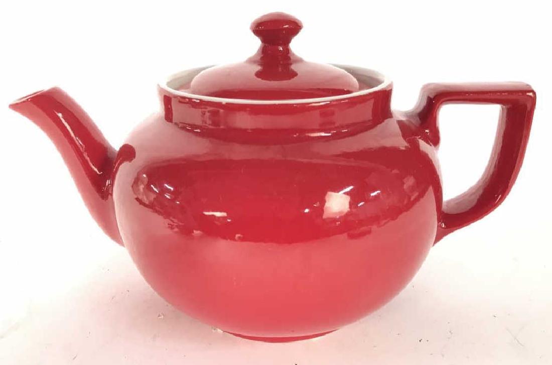 Red Toned HAMMACHER SCHLEMMER Porcelain Teapot: Teapot is red toned and porcelain. Underside reads HAMMACHER SCHLEMMER. Piece measures approx 5 inhces tall 9 inches wide with spout and handle. tableware, teapot, kitchen accessory 6.