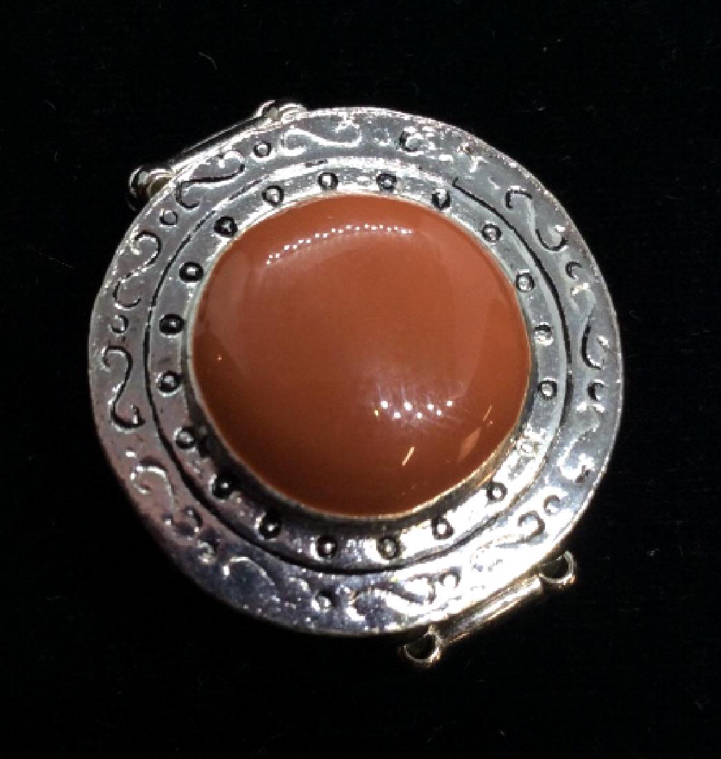 Women’s vintage costume Cocktail Ring: Silver toned metal with textured curling line design, red toned poss enamel center design, stretch band, fits an approx size 10, Face Measures approx 1 in long, Women’s vintage estate jewelry, state