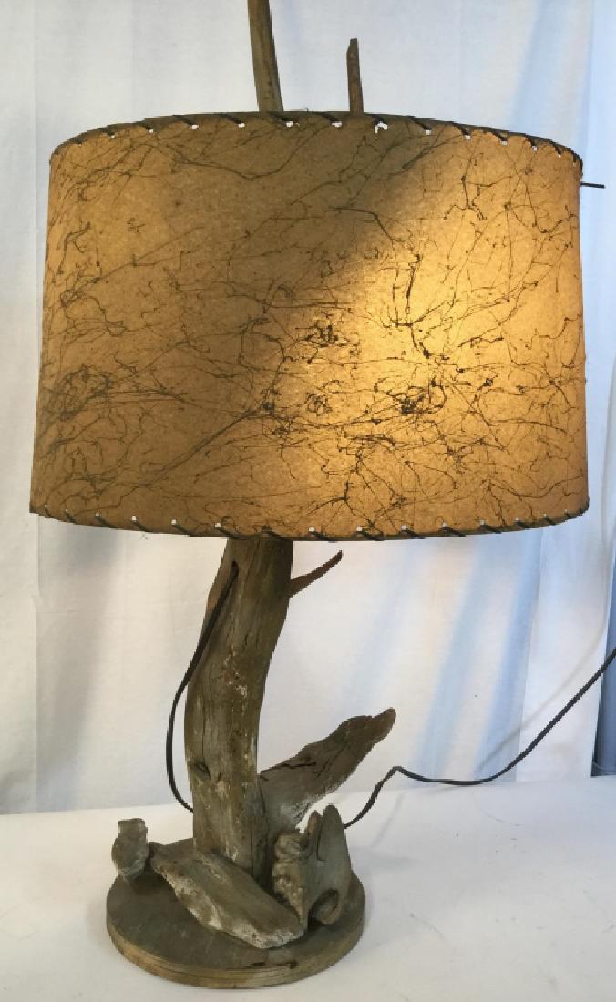 Vintage Hand Crafted Driftwood Table Lamp: 34 in H. Shade 58 in. circumference. Plywood base, some moisture warp, approx 12 in. diameter. Pieces of driftwood nailed into base. Wiring drilled through primary branch, lining parallel to wood. Pus