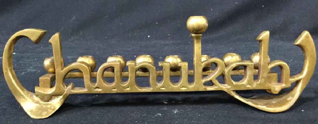 Gold Toned Brass Chanukah Menorah: Piece is gold toned & brass. Front of pieces structure reads CHANUKAH. Measures approx 9.5 inches long, 2.5 inches tall. ceremonial accessory, judaica hebraica 6.