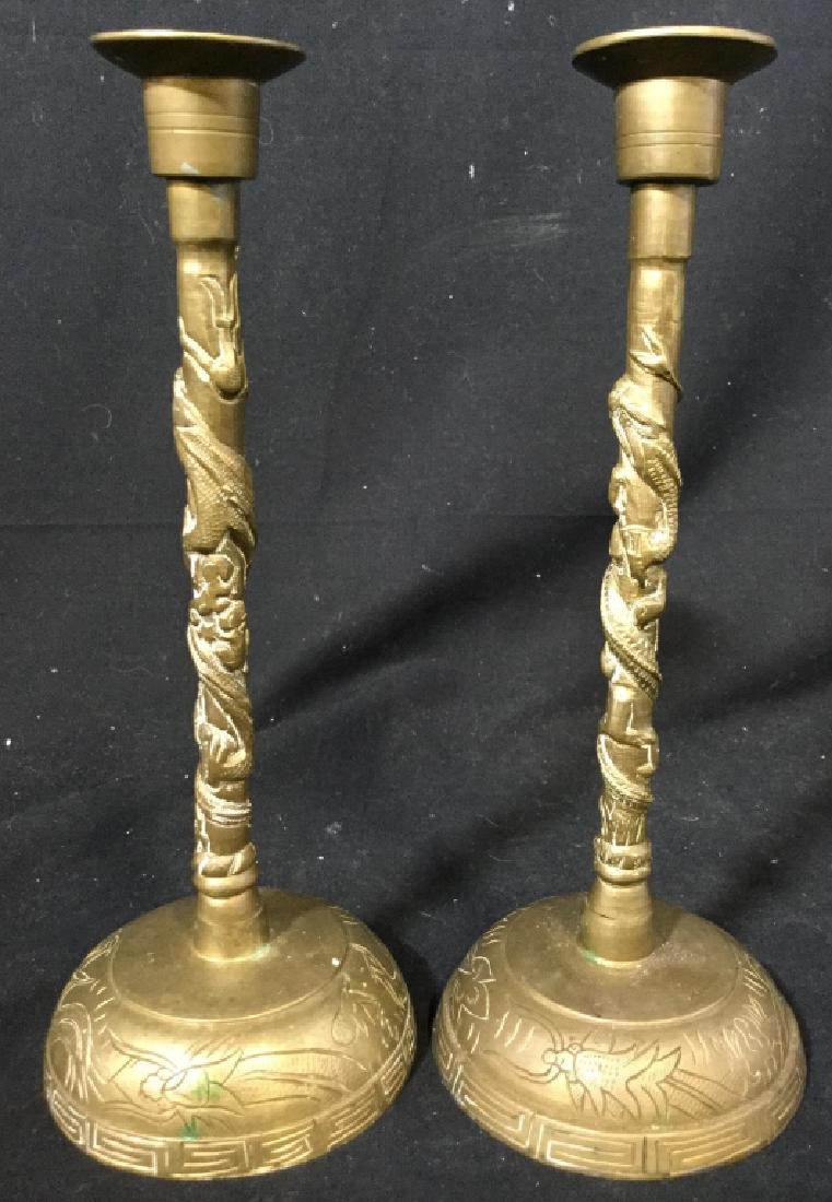Pair Asian Gold Toned Brass Candlesticks: Lot includes 2 Candlesticks. Each piece is gold toned and brass. Each measures approx 10.5 inches tall 4 inches wide. Contains intricate detail. Both appear to be vintage tableware, decorative accesso