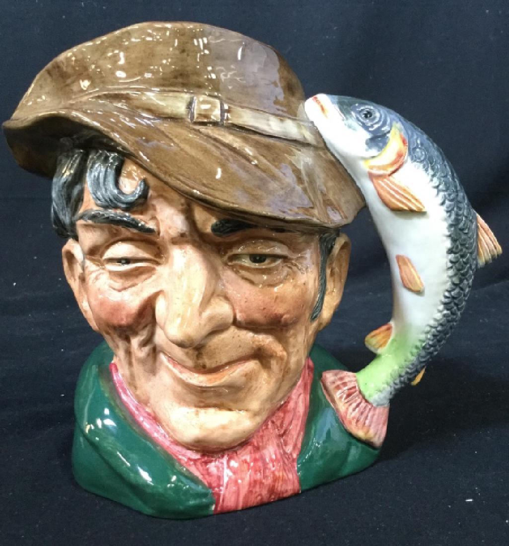 DOULTON “THE POACHER” Porcelain Mug: Underside of piece reads ROYAL DOULTON THE POACHER. Piece depicts an elderly male head & a fish Figural as a handle. Measures approx 6.5 inches tall 7 inches wide. decor piece, mug, decorative tablewa