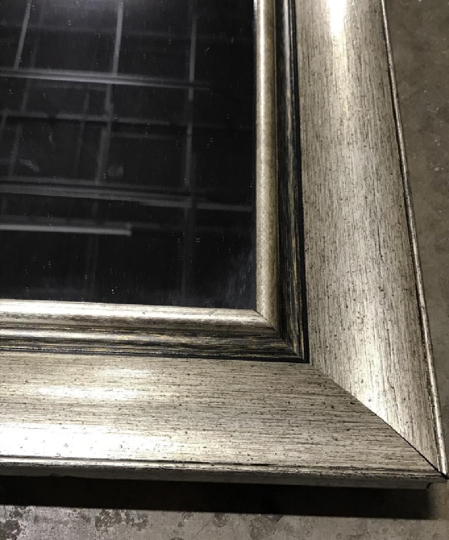 Tall Mirror in Silver Tone Frame: Tall mirror in silver toned wood style frame. Light in weight. Some tape residue on frame. Measures approx 52.75 inches in height by 16.75 inches in width. Interior home decor, wall mirror, floor mirr